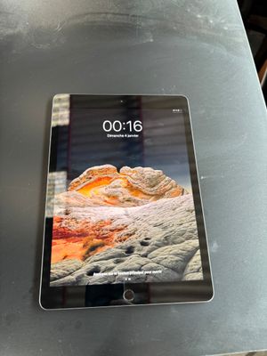tablet computer sitting on top of a table on a metal surface