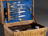 a wicker picnic basket filled with silverware and utensils