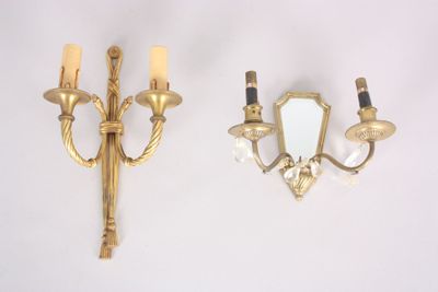 two sconces that are on the wall with a mirror