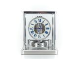 une horloge argentée ornée de chiffres romains bleus