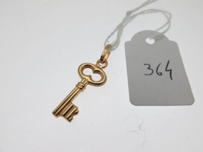 une clé en or à laquelle est attachée une étiquette, posée sur une table