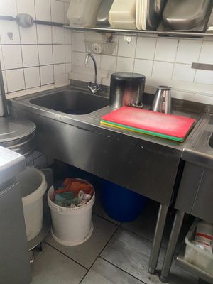 une cuisine avec un évier et une poubelle