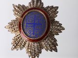 an image of a blue and gold broochle with a crown on it