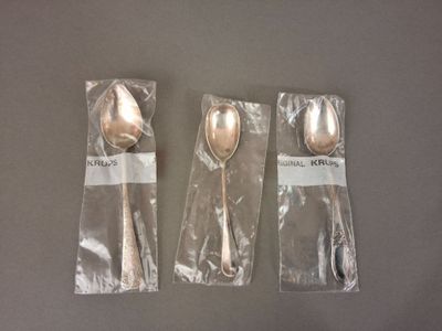 trois cuillères en argent et deux cuillères en argent emballées dans du plastique