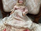 a doll that is sitting on a chair in a room