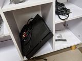 a black bag sitting on top of a white shelf in a room
