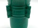 un vase vert orné d'un nœud sur l'anse