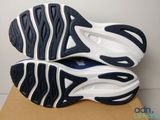 the bottom of a pair of blue and white shoes on top of a cardboard box