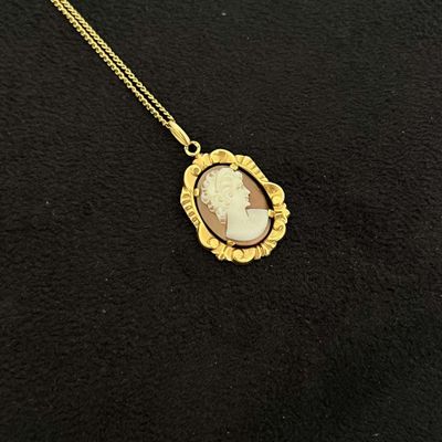 un gros plan sur un collier en or orné d'une image représentant une femme