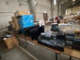 a lot of electronic equipment on a table in a warehouse