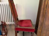 a red chair in the corner of a room next to a white radiator