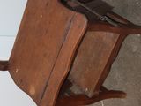 a small wooden chair that is hanging from the wall