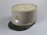 grey hat with gold trim on top of it sitting on a gray surface