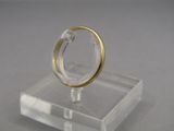 a gold ring sitting on a clear stand on a table