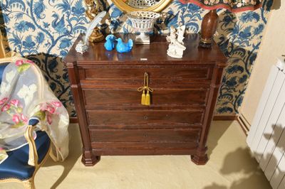une commode avec un miroir et une chaise bleue dans une pièce
