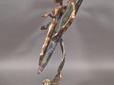 statue of a woman on a surfboard on a metal base