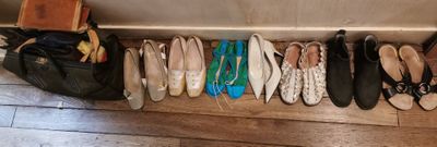 Plusieurs paires de chaussures sont alignées en rangée sur le sol