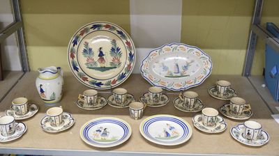 de nombreuses assiettes et tasses posées sur une étagère dans une pièce
