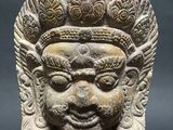 a stone head of a man with a crown on top of it