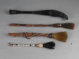 four different types of brooms and brushes are lined up on a table