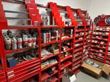 de nombreuses étagères rouges dans une pièce où se trouvent de nombreuses boîtes de peinture