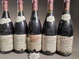 six bottles of wine are lined up in a row on a table