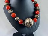 a close up of a necklace on a mannequin with red beads