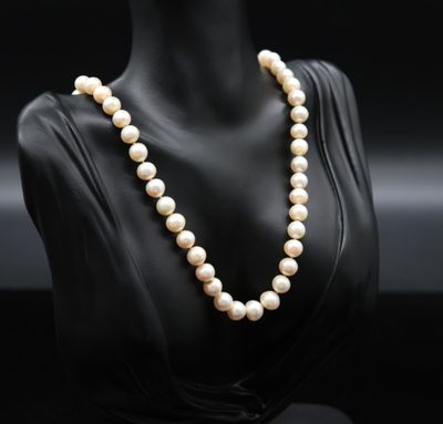 a white pearl necklace on a mannequin head