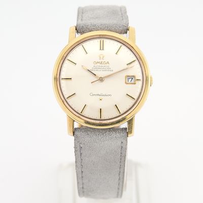 une montre en or et en argent avec un bracelet en cuir gris
