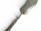 an old silver spoon with a metal handle on a white surface