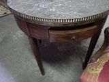 une petite table avec un plateau en marbre et une chaise à l'arrière-plan