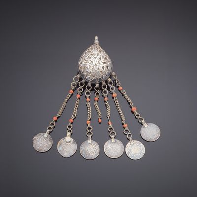 a silver pendant with coral beads and silver coins