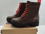 pair of brown boots with orange laces sitting on top of a cardboard box