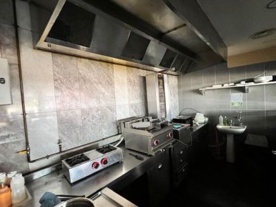 une cuisine équipée d'une cuisinière, d'un évier et d'une plaque de cuisson