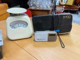 a table with a scale, a radio, and other items on it