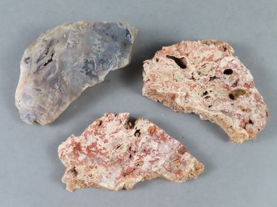 trois morceaux de roche posés sur une table, sur fond gris