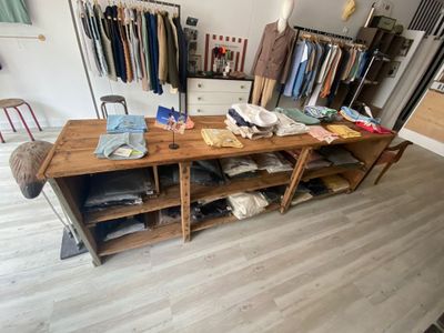 a large wooden table with clothes on it in a room