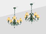 two green chandeliers with yellow lamps hanging from the ceiling