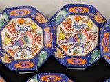 six blue and orange plates with designs on them sitting on a table