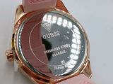 a close up of a pink watch on a white surface