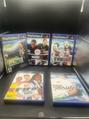 Trois jeux PlayStation sont posés sur une table devant un ordinateur portable