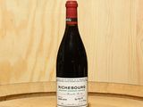 a bottle of wine sitting on top of a barrel