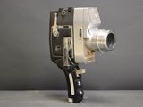 an old movie camera sitting on top of a table next to a gray wall