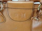 a tan purse with a tag on it