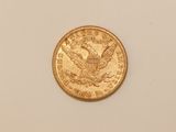a close up of a gold coin on a white surface