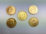 quatre types différents de pièces d'or sur une surface blanche
