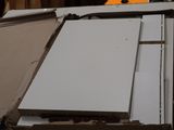 a pile of white refrigerators sitting on top of a pile of cardboard