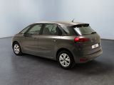 the back of a grey car is parked in a room