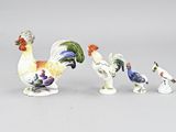 cinq figurines de coqs exposées sur une table