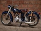a blue motorcycle that is parked in front of a brick wall